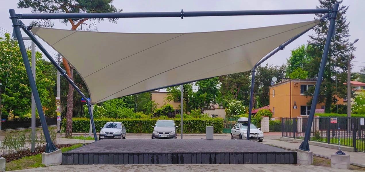 Ozdobne zadaszenie membranowe (żagiel) na stalowych masztach nad placem