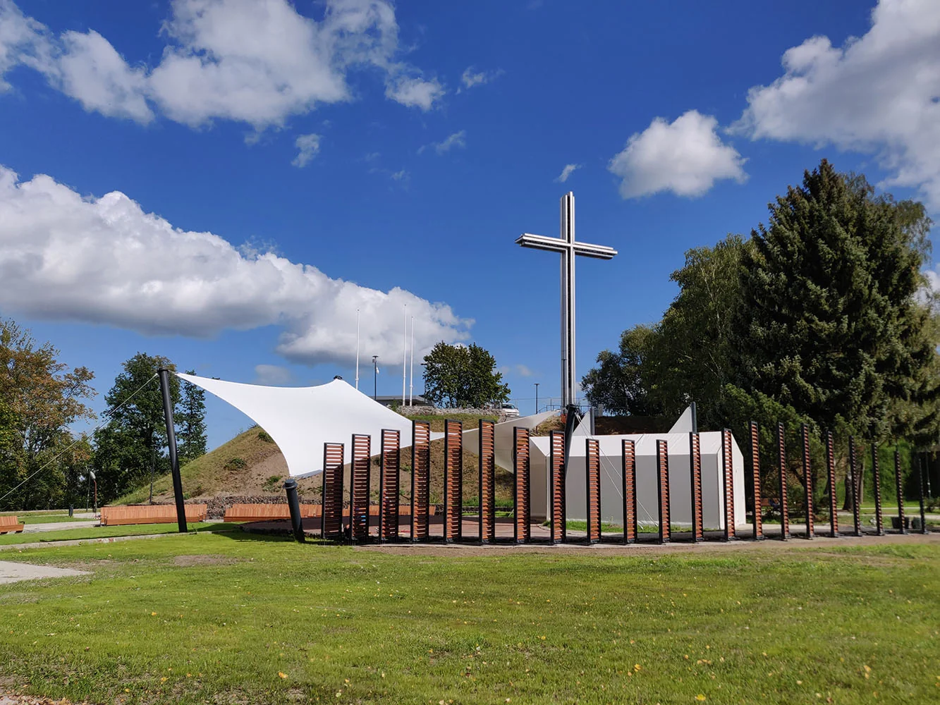 Scena plenerowa z białą membraną napinaną przy monumencie z krzyżem