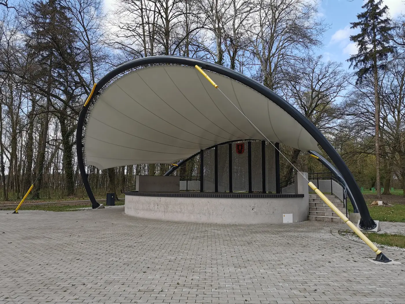 Membranowe zadaszenie sceny plenerowej (muszli koncertowej) na łukowej konstrukcji w parku